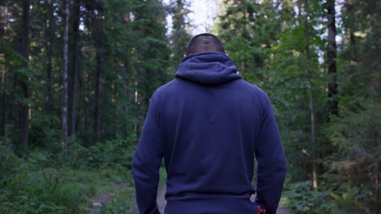 Мужик в лесу со спины